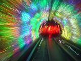Colorful motion blur of a subway tunnel with red lights at the end taken from the back of a moving tube train for a fun psychedelic background with receding perspective