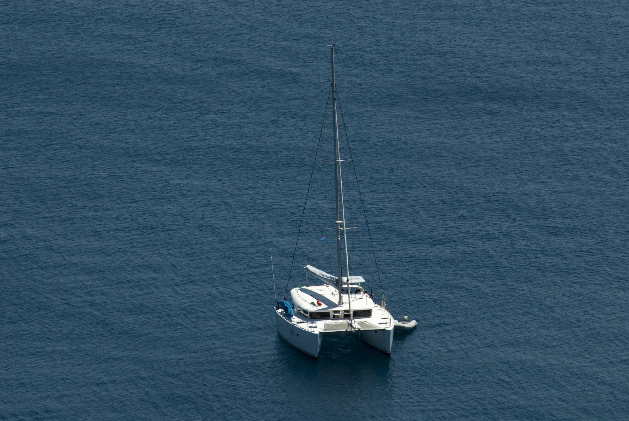 an image of Luxury catamaran moored offshore in mid ocean with copyspace, high angle view