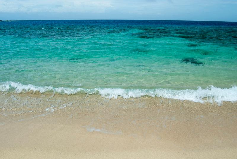 Environmental background of an idyllic sandy beach and clear blue tropical ocean suitable for travel and vacation