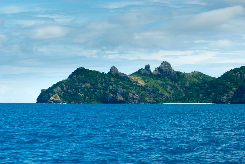 View across open blue ocean while cruising offshore of Yasawa Islands Fiji showing the rocky topography of these beautiful tropical islands