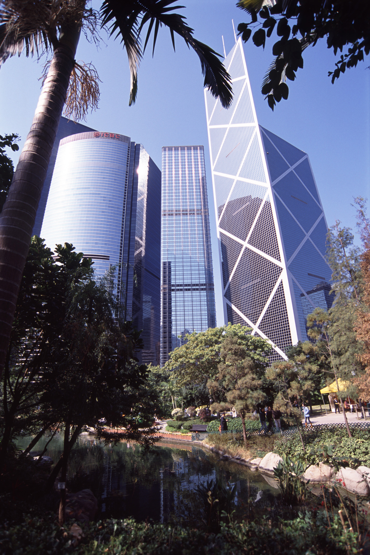 an image of downtown hongkong, modern skyscrapers seen from the contrasting tranquility of an urban park