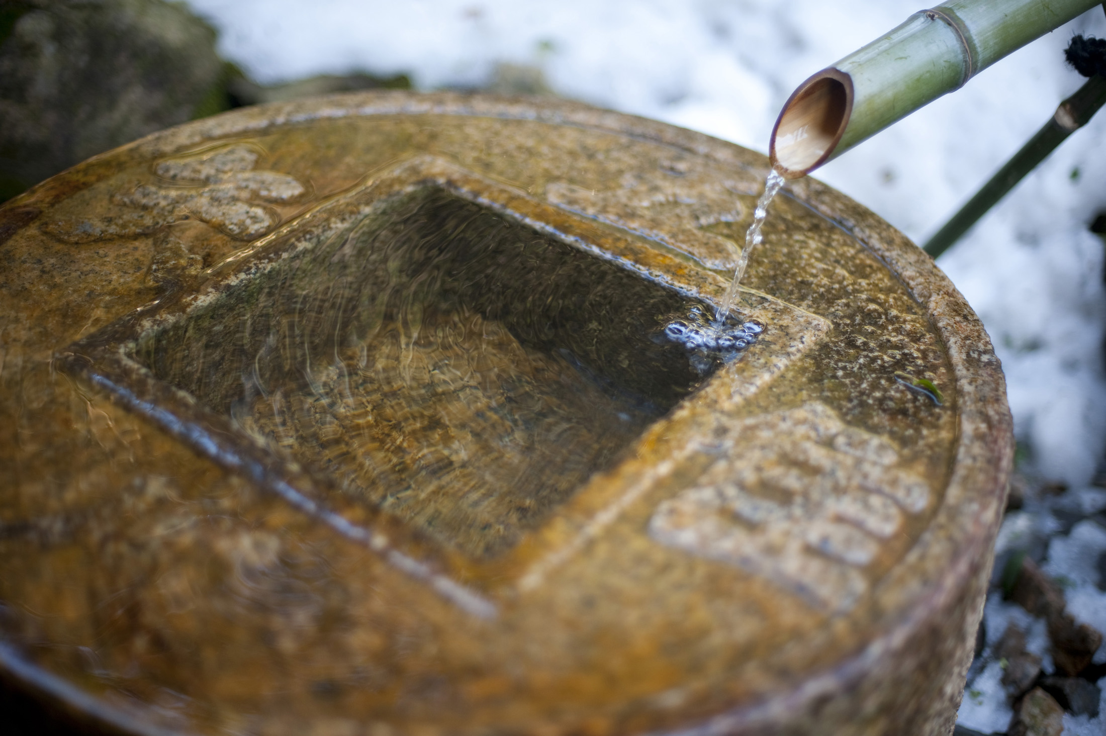 an image of Tsukubai at RyoÂan-ji, it is traditional for Buddhist temples for visitors to purify with the ritual washing of hands and mouth, water running from a tube called a kakei