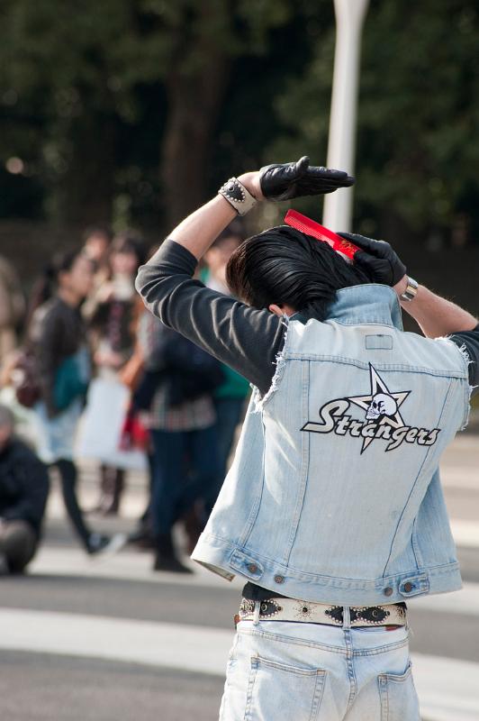 A rocker in Tokyos Yoyogi Park tends his hair - not model released