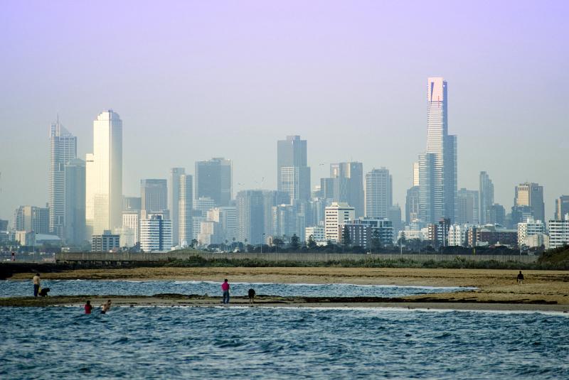 The distant Melbourne city skyline and CBD buildings from a beautiful, quiet suburban ocean beach.