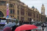 A busy winter scene and umbrellas on Flinders street in Melbourne city, Australia.