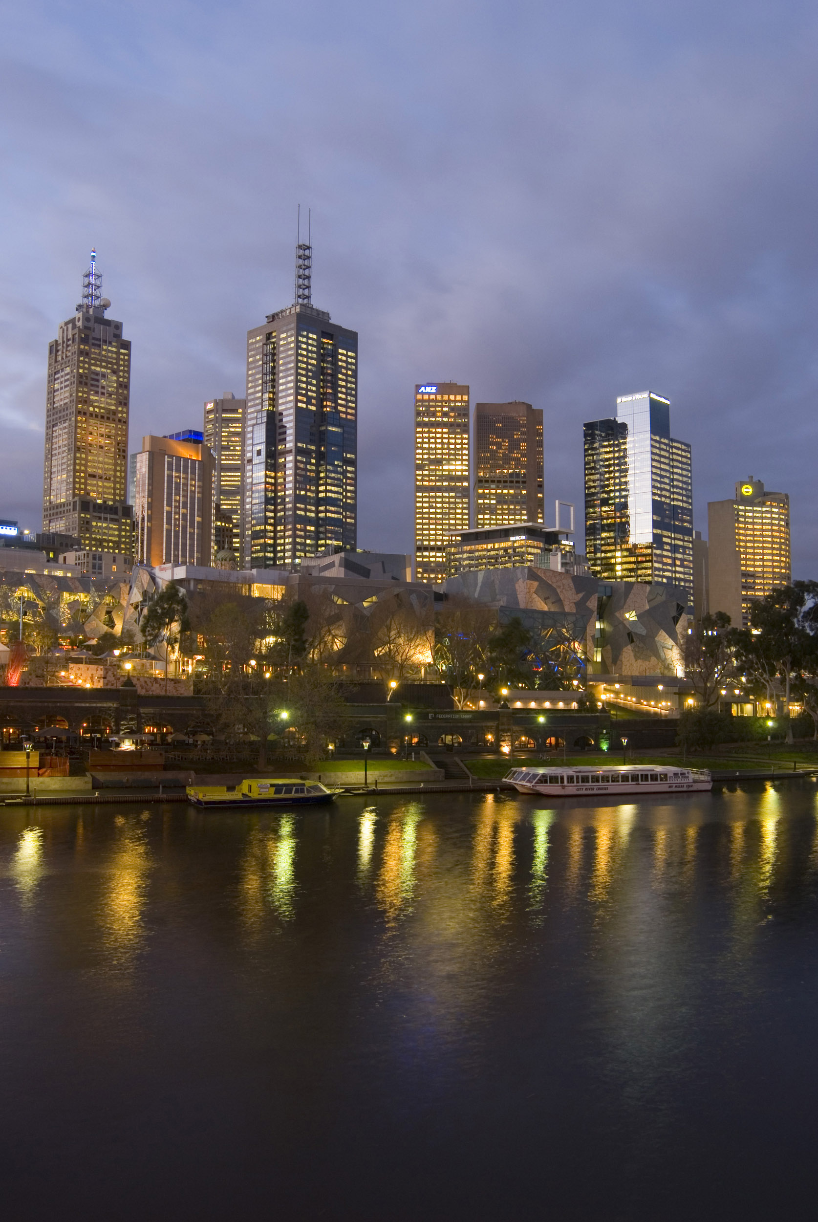 an image of A portrait of the beautiful Yarra River and illuminated Melbourne city skyscrapers at night.
