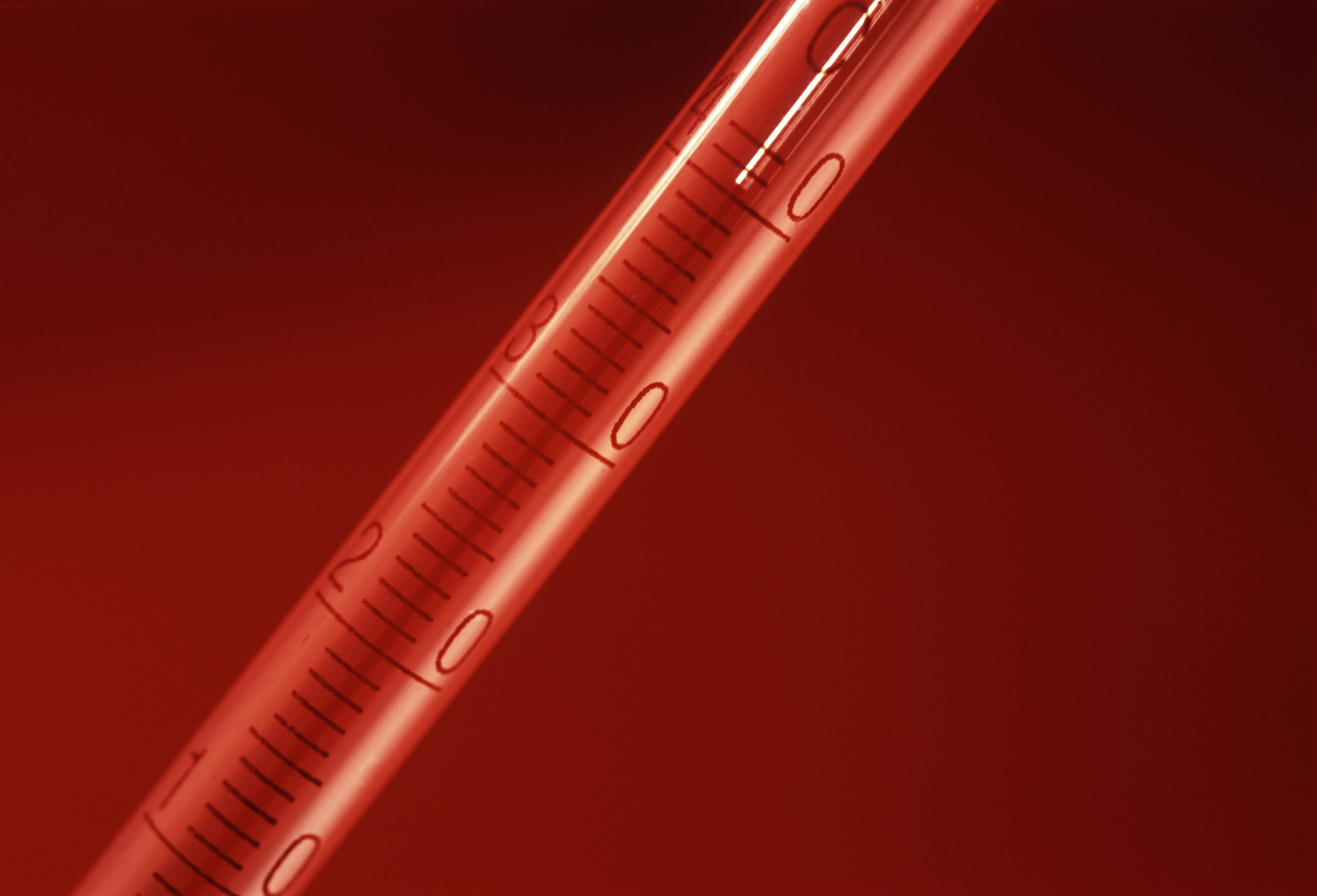 an image of Close Up of Red Hot Thermomter on Red Background, Studio Shot