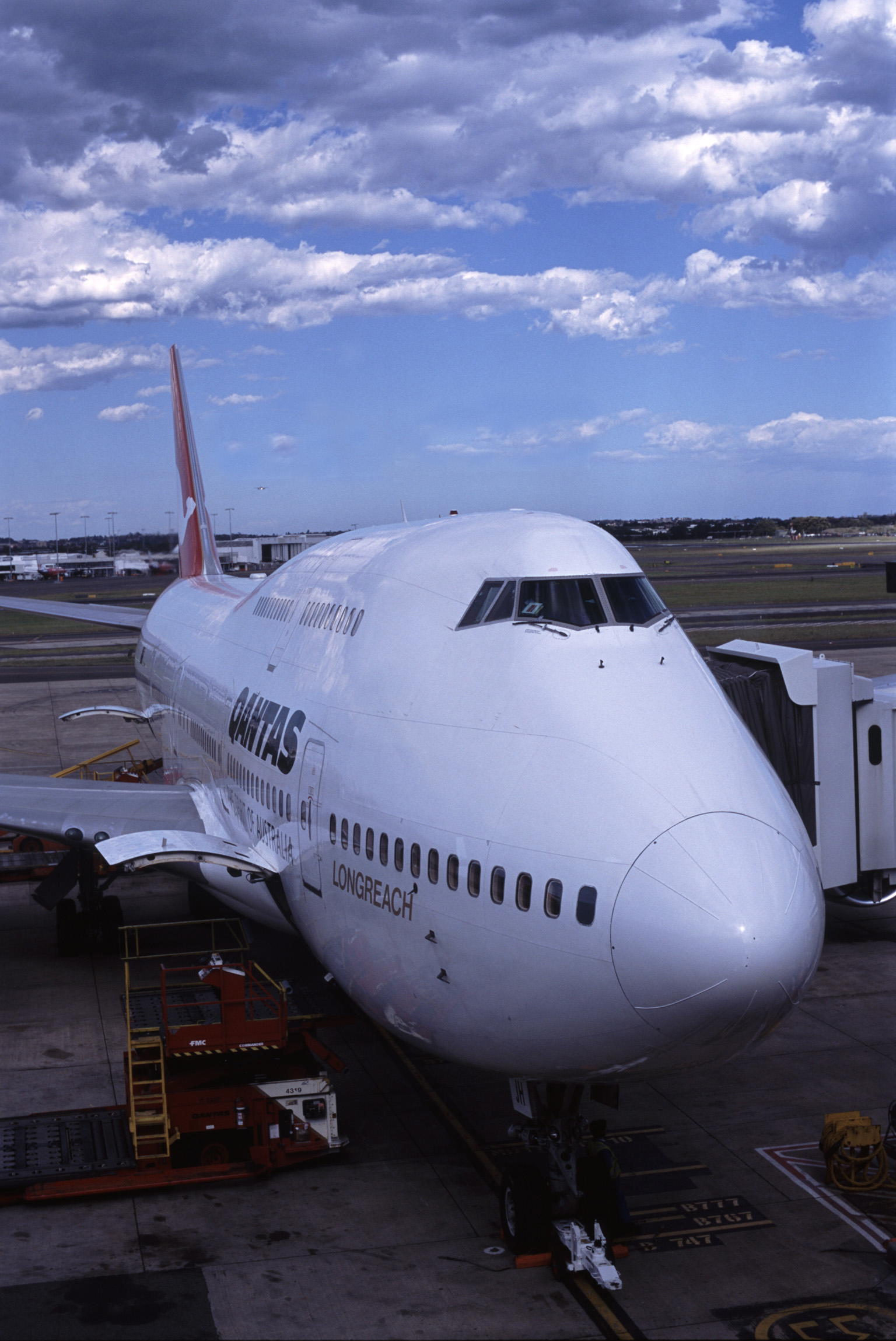 an image of Preparing Airplane for Take Off on Tarmac at Airport with Boarding Bridge Attached