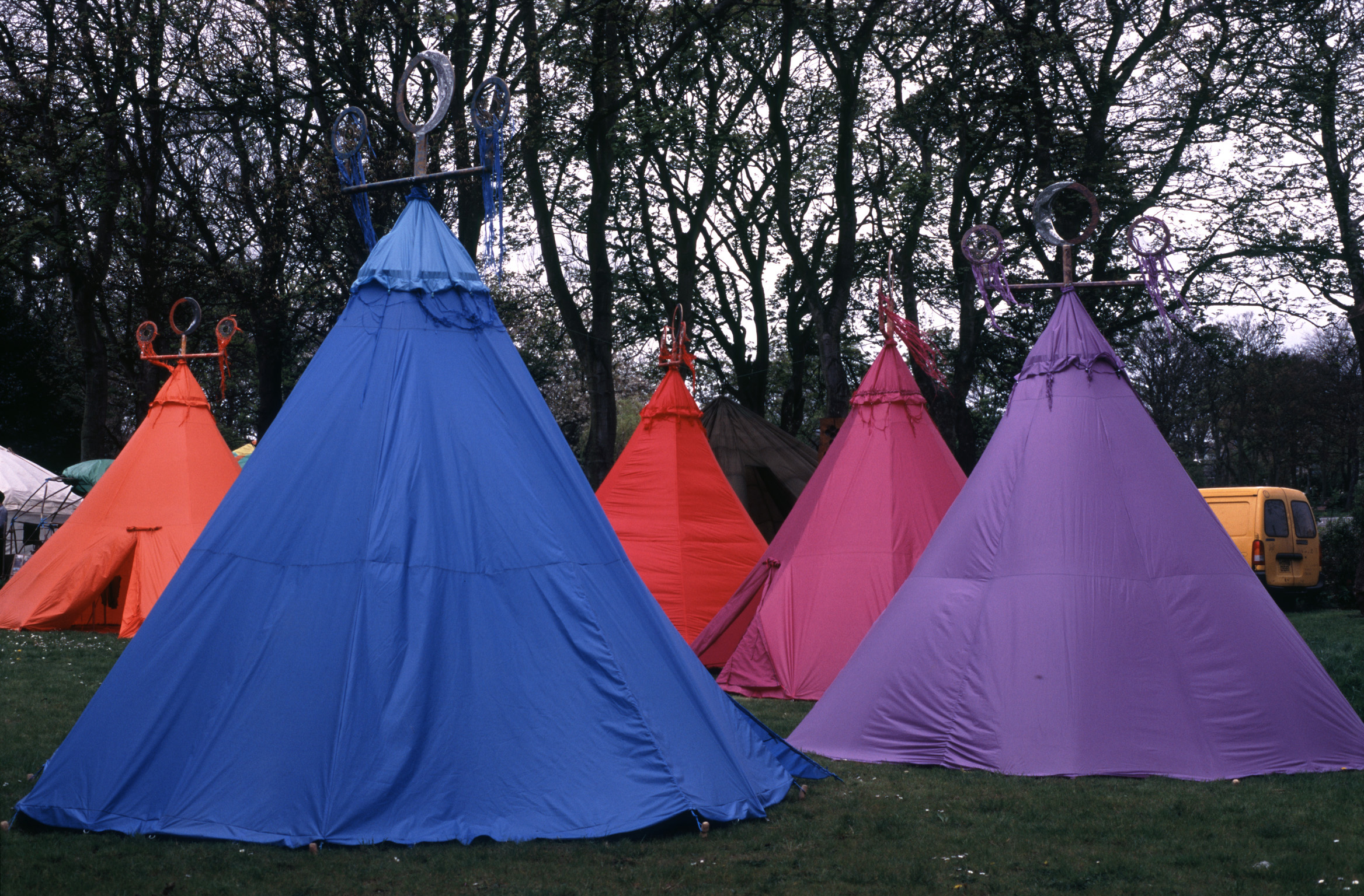 an image of Group of colorful blue, orange and pink tents pitched on a wooded campsite conceptual of a vacation, travel and healthy lifestyle