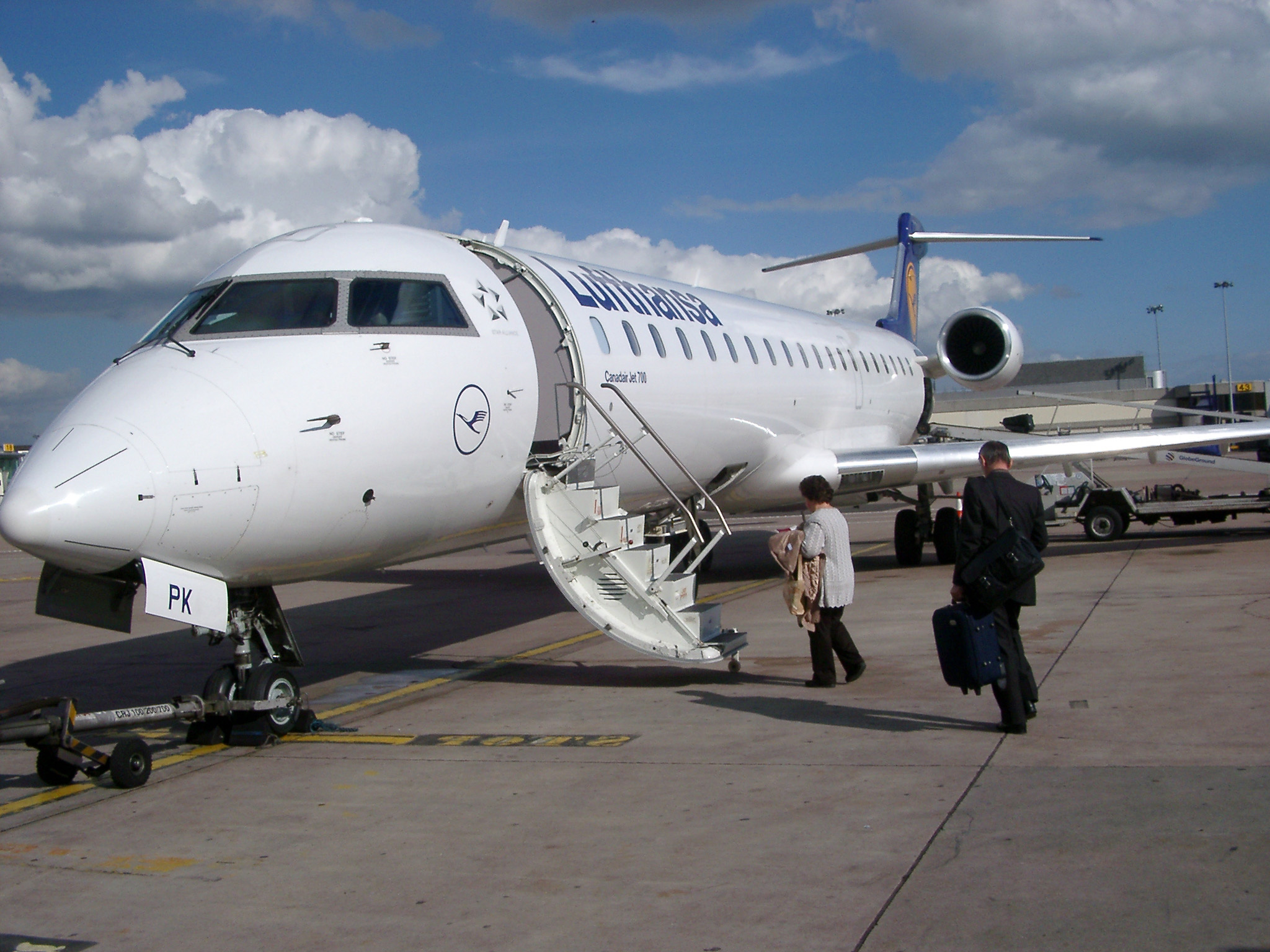 an image of Two Passengers Boarding Small Airplane on Tarmac at Airport