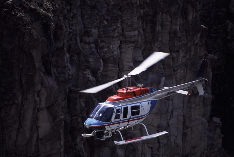 Helicopter on a sightseeing flight Helicopter on a sightseeing flight flying on a dark background with copyspace conceptual of travel and vacations