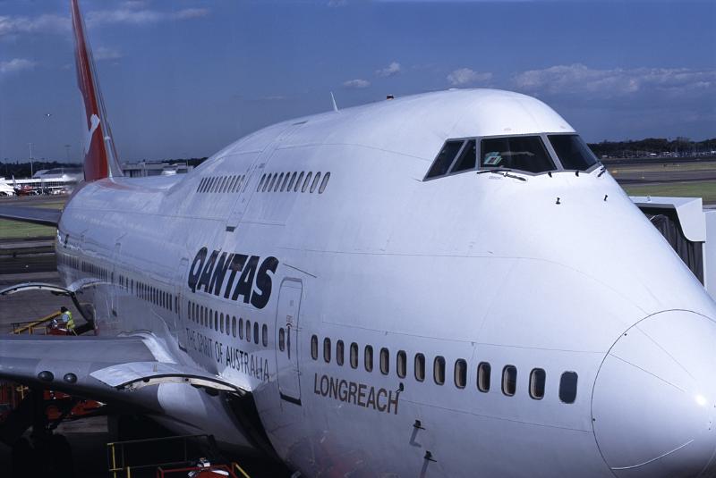 Qantas plane on the apron at an airport Qantas passenger airplane on the apron at an airport refueling and embarking passengers for an international flight, close up view of the front and pilots cockpit