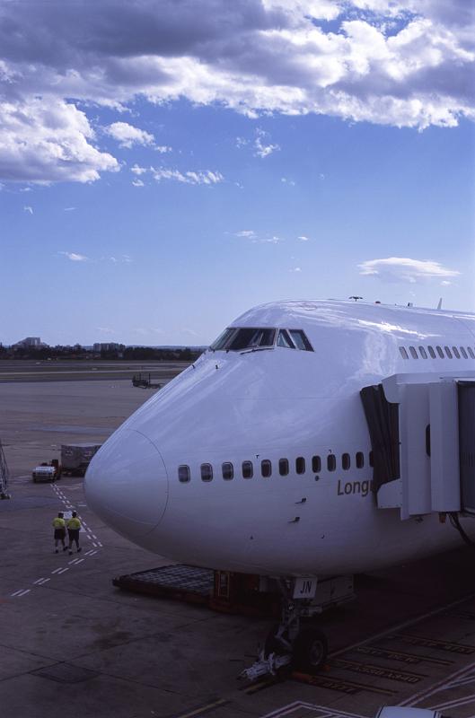 474 Jumbo aircraft loading for departure 474 Jumbo aircraft loading for departure with a passenger skybridge attached to the side for embarkation as it stands on the apron at the airport