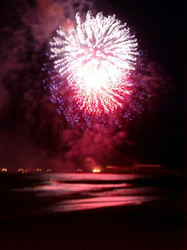 Pink Fireworks Exploding in Sky Above Water Long Exposure of Pink Fireworks Exploding in Sky Above Water at Night