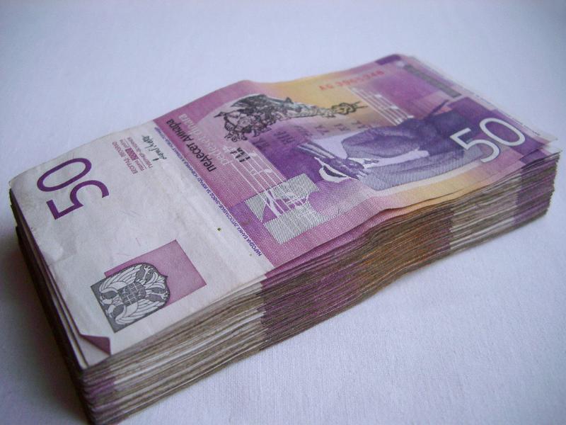 Wad of old Yugoslav cash Wad of old Yugoslav cash in denominations of 50 stacked carefully on a white background
