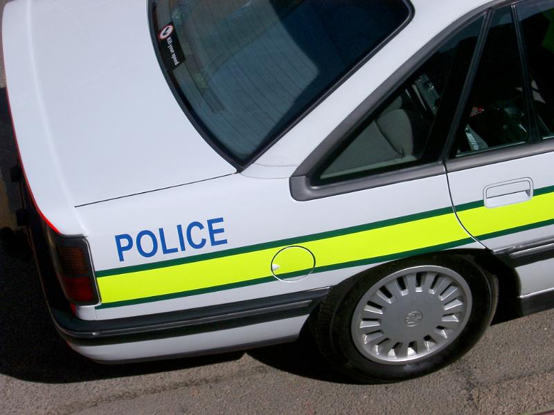 Police car Police car with a high angle view of the rear boot and the yellow neon stripe with the word - Police - on the side