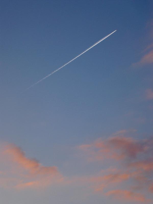 Jet trail or contrail in an evening sky Jet trail or contrail in an evening sky with colorful pink clouds of condensed water vapor from a passing aircraft