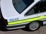 Police car with a high angle view of the rear boot and the yellow neon stripe with the word - Police - on the side