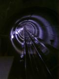 Blurred receding view of a rail tunnel taken from a moving train disappearing in to the darkness in a rail travel, commuting, and vacation concept