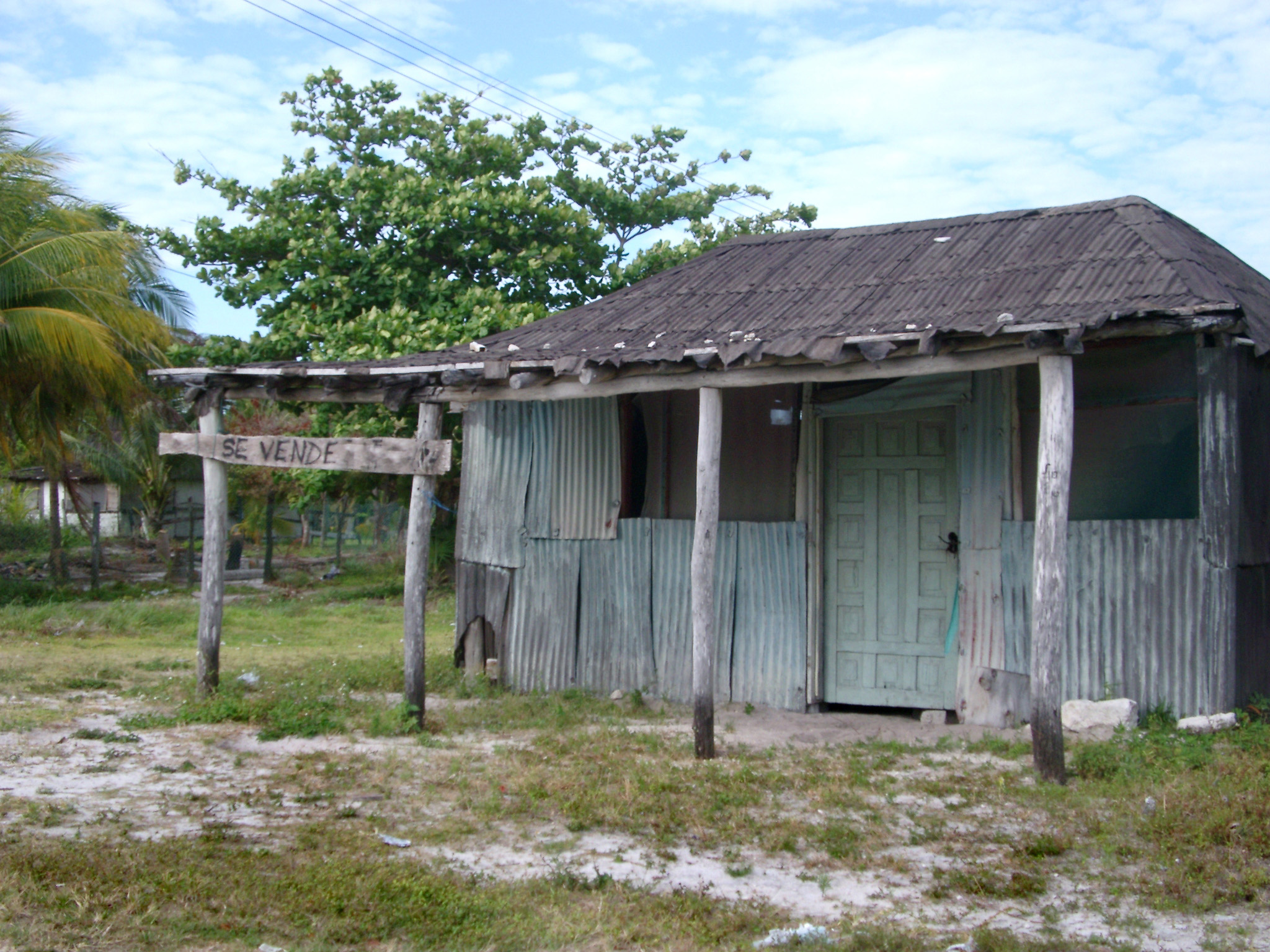 an image of Small Old Vintage House on Grassy Landscape with Tin Sheet Wall. Located in Mexico