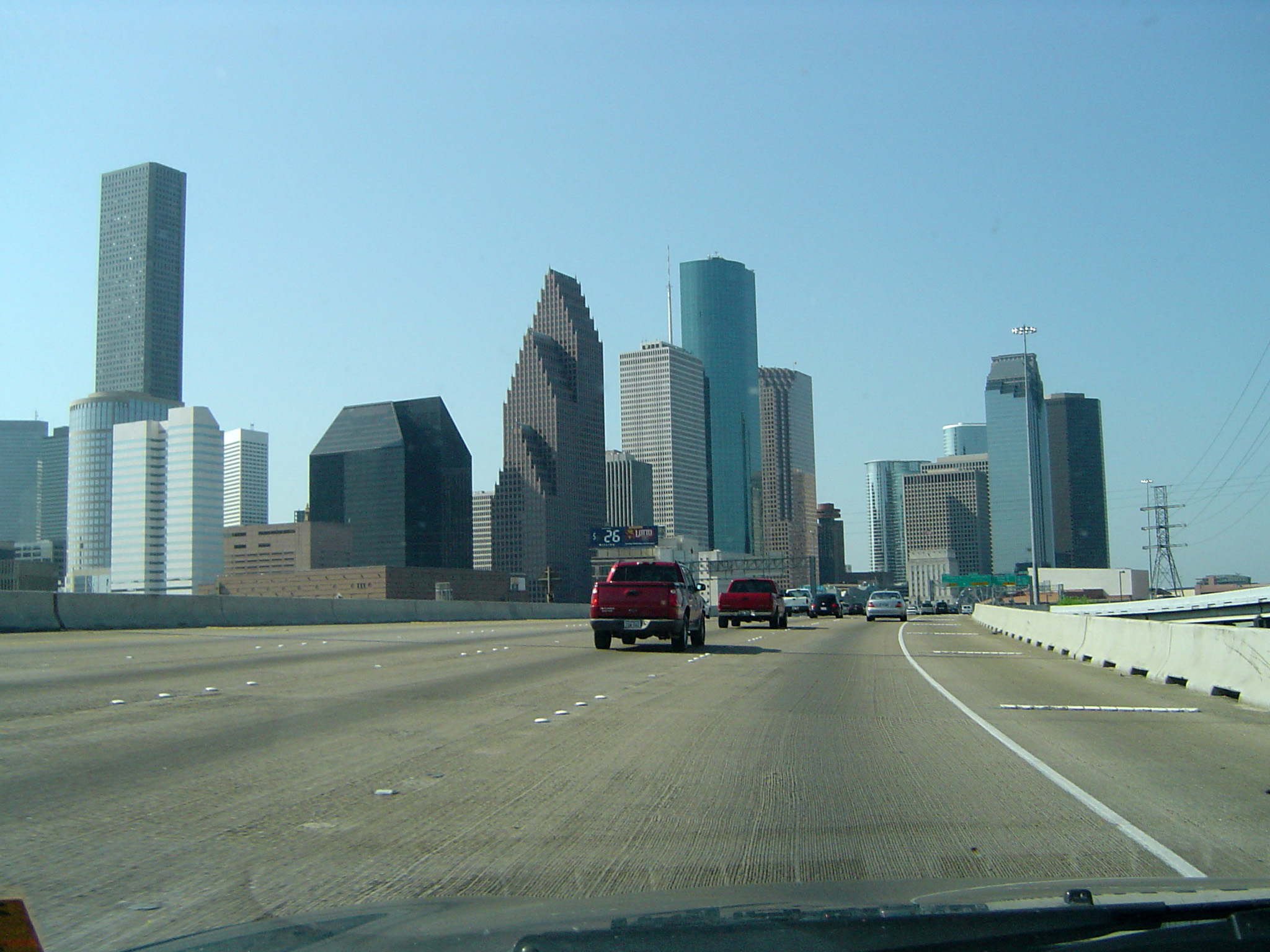an image of Cars driving on a freeway in America towards a city skyline with modern skyscrapers, drivers perspective
