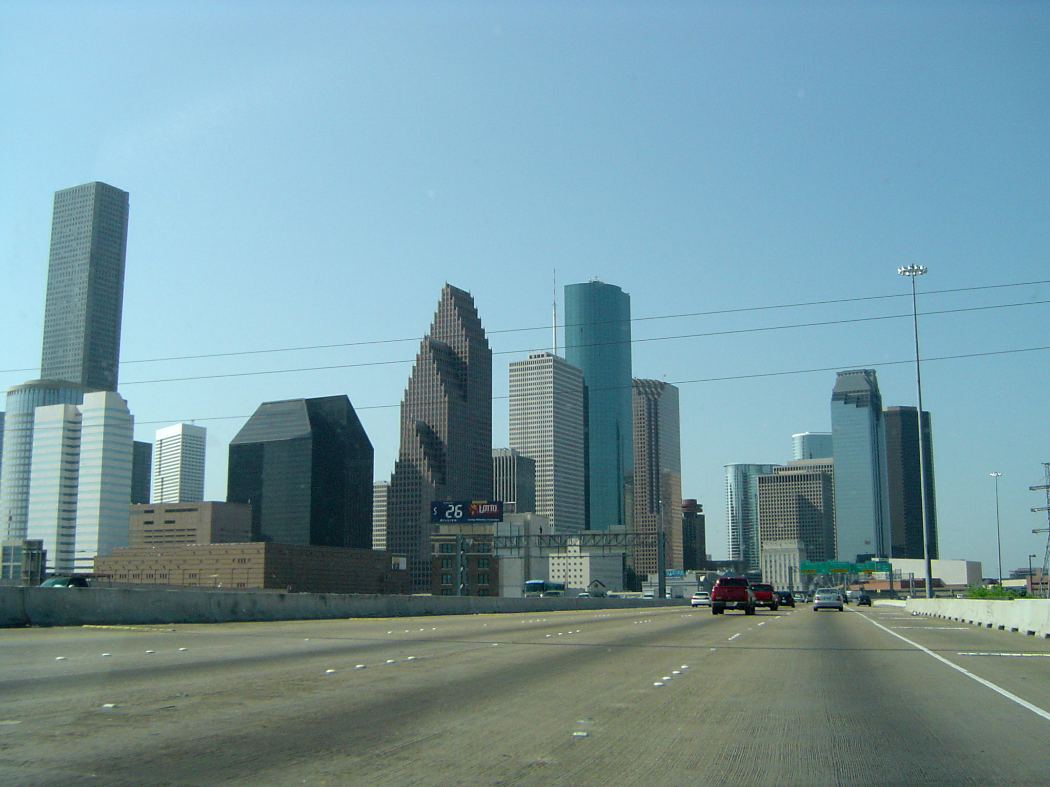an image of Attractive Architectural Buildings Along Freeway on Light Blue Sky Background.