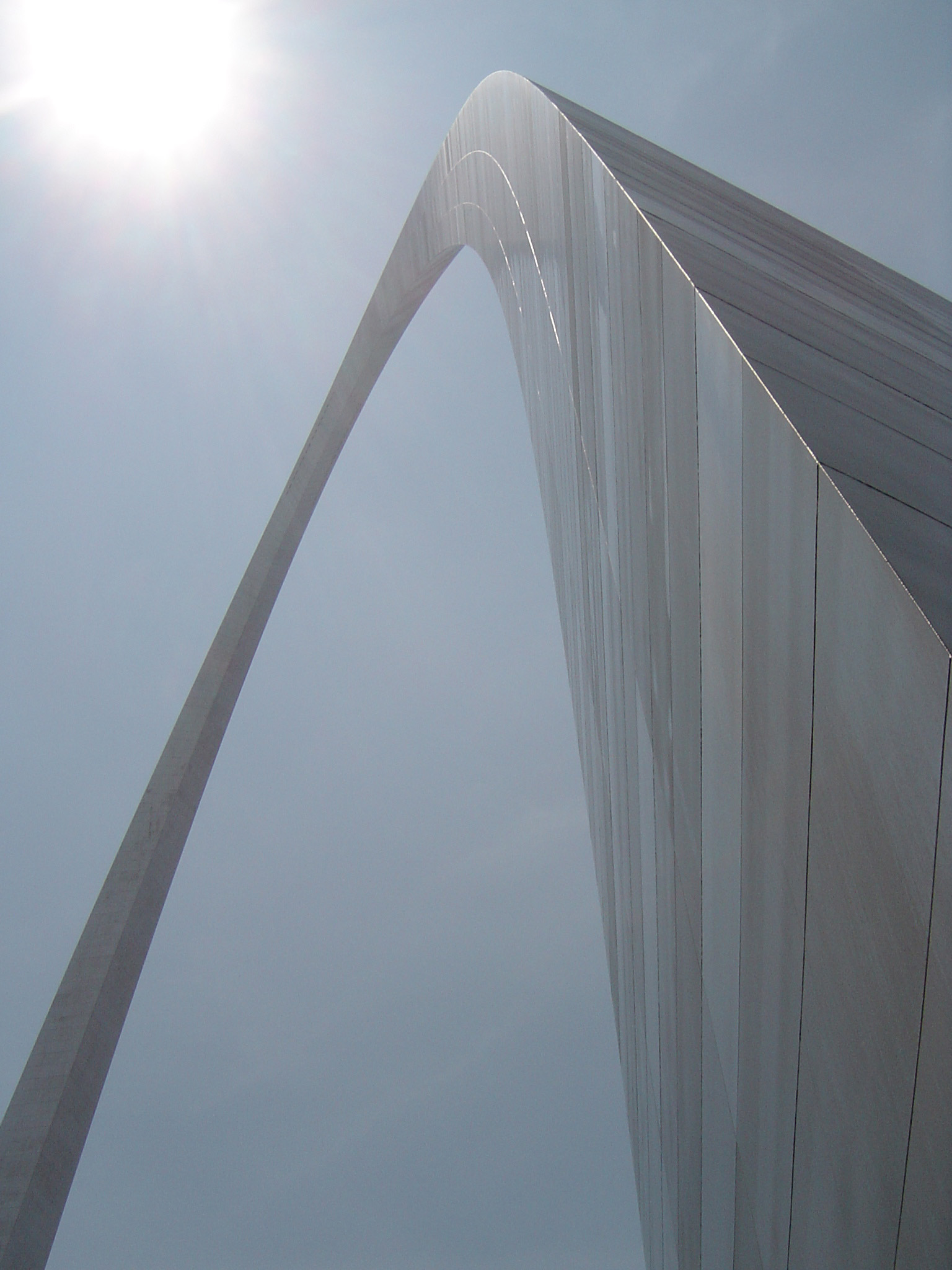 an image of View looking up the curve of the Gateway Arch, St Louis, USA against a blue sky with sunburst