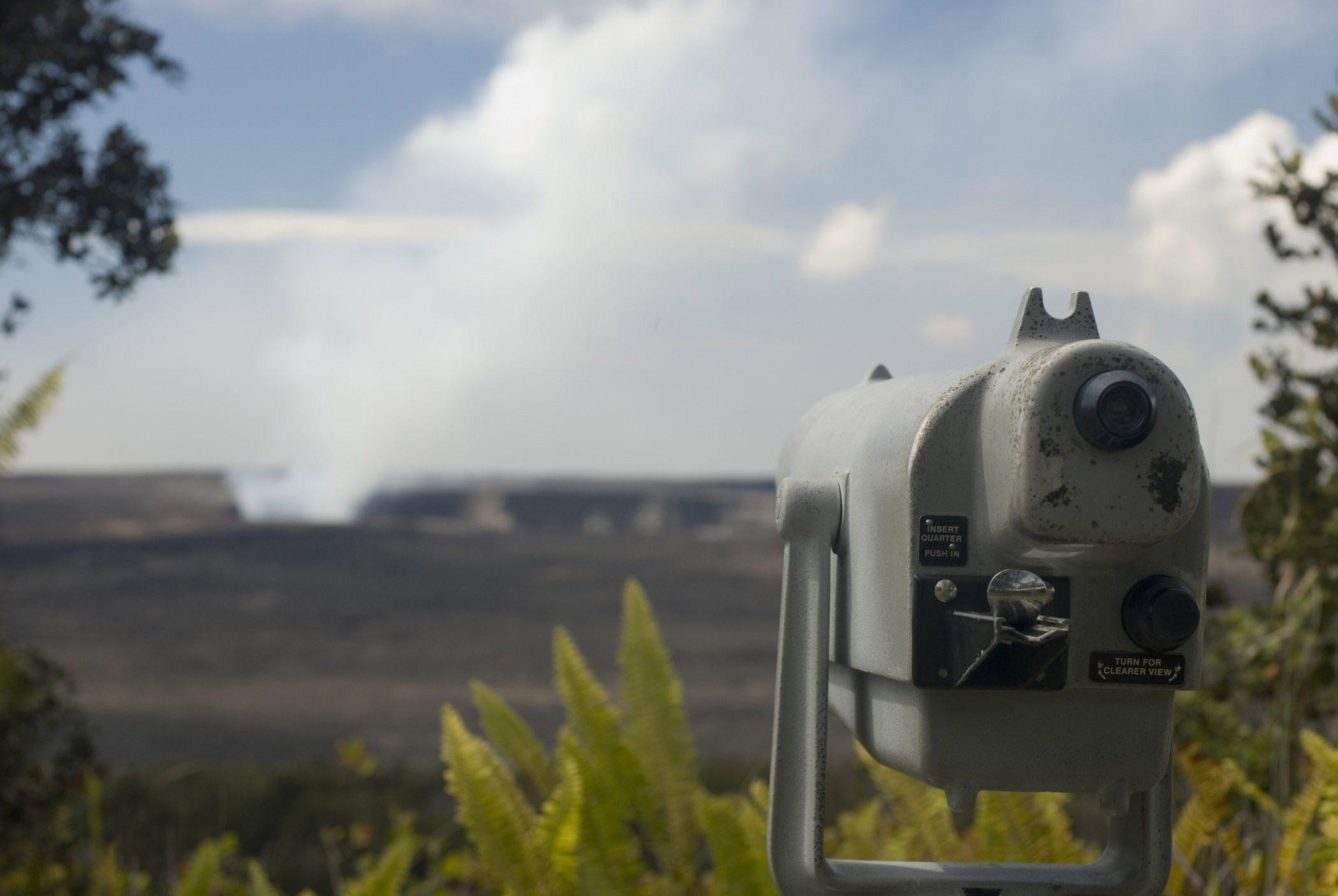 an image of Telescope overlooking the Kikauea Crater with the Haleamaumau crater in the center of the Kilauea caldera releasing smoke and steam - the heart of Kilauea volcano
