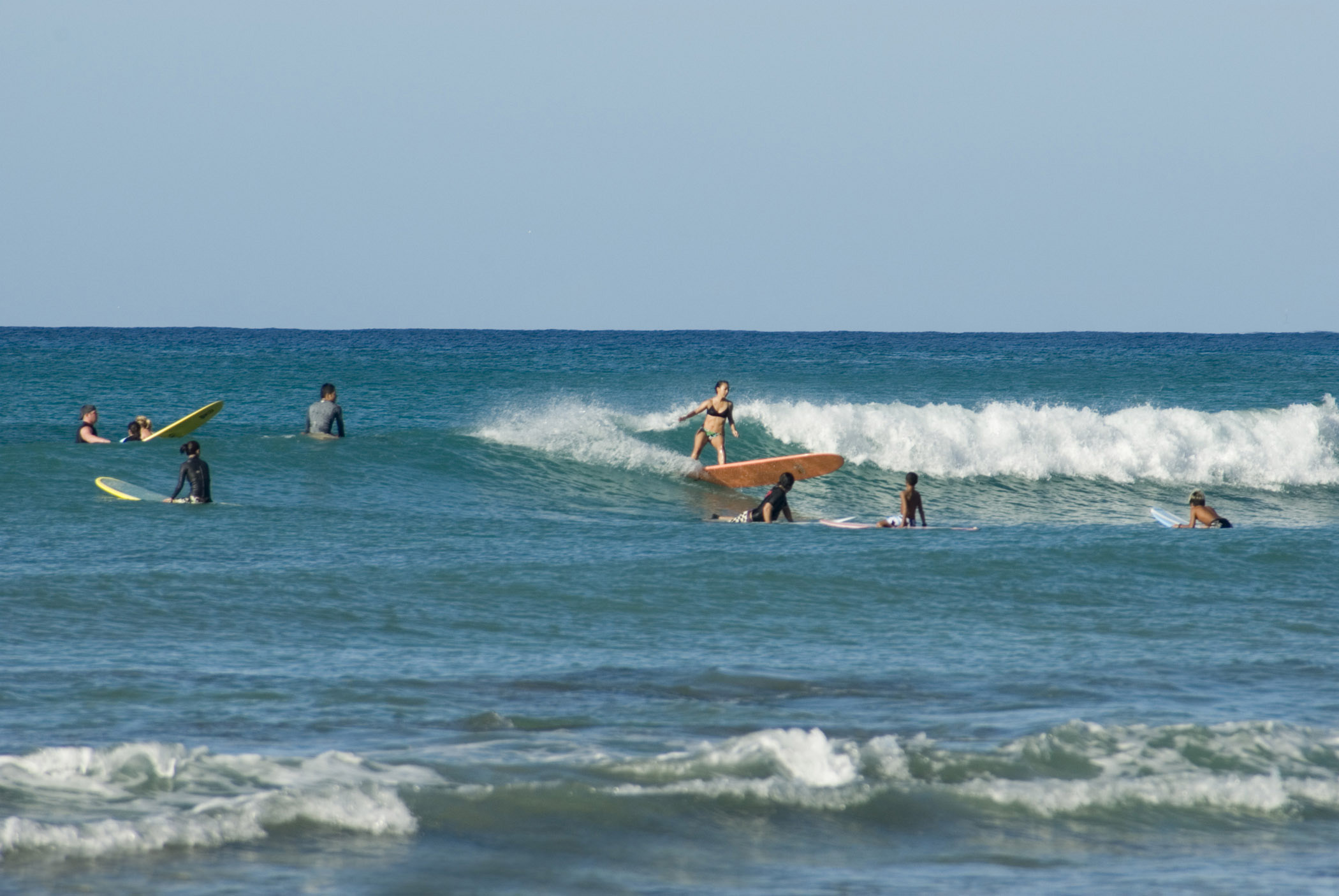an image of Surfers surfing at Waikiki beach, Hawaii, a favorite tourist destination and surfers paradise