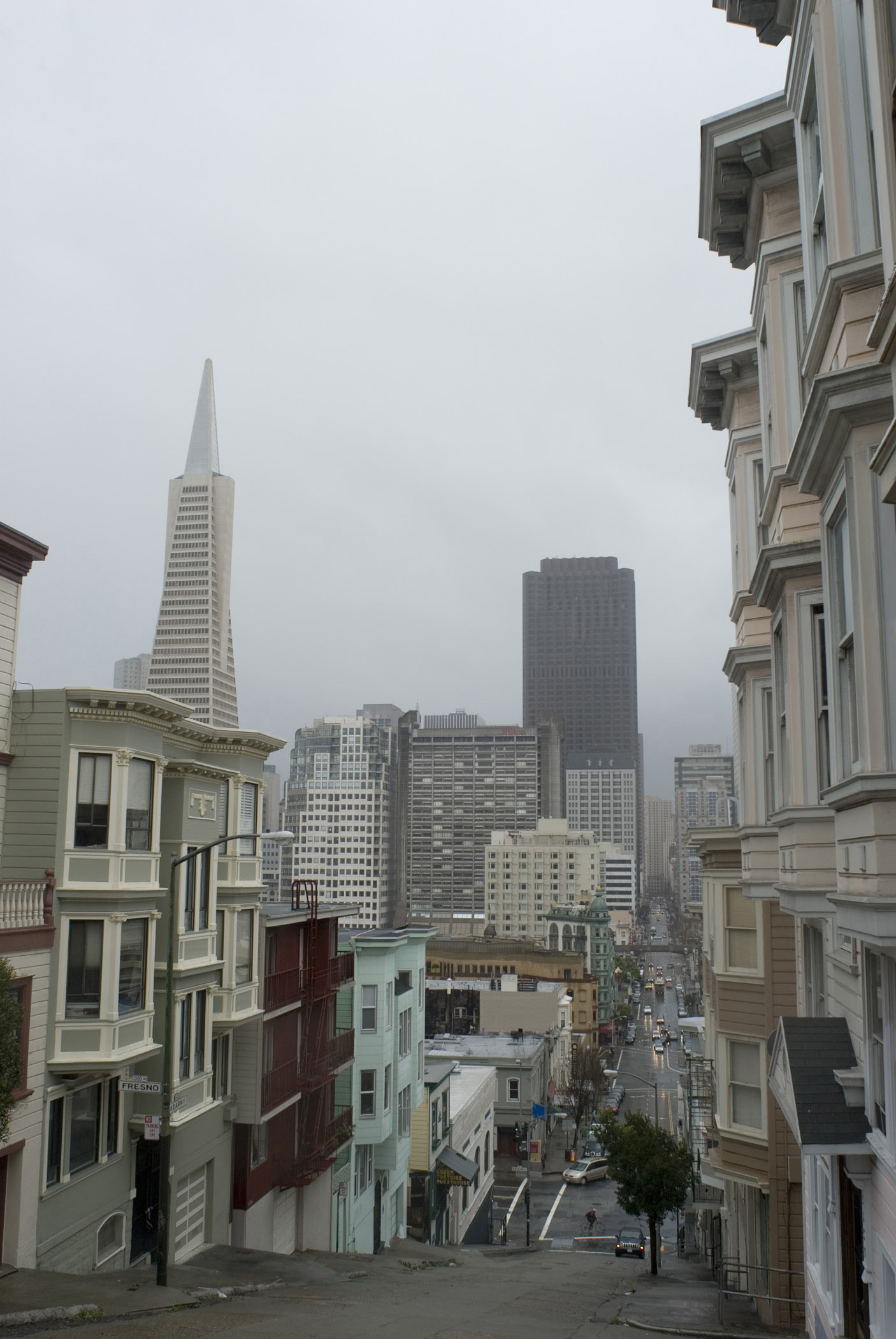 an image of Rainy day in San Francisco looking doen one of the sxteep hills to the architecture of the CBD with its landmark tower and high-rise buildings