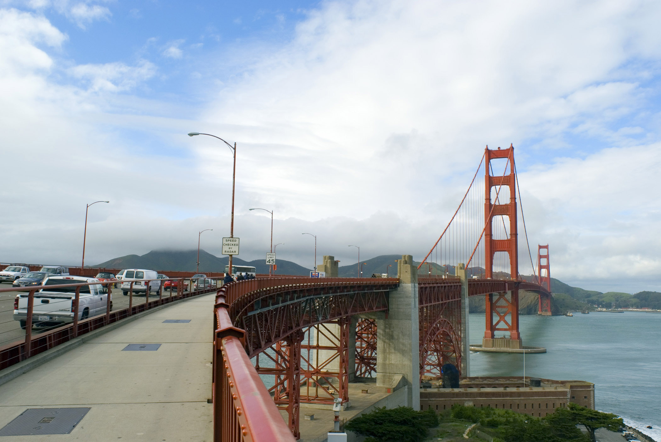 an image of Walk Along Famous Golden Gate Bridge in San Francisco. Isolated on Light Blue and White Sky Background.
