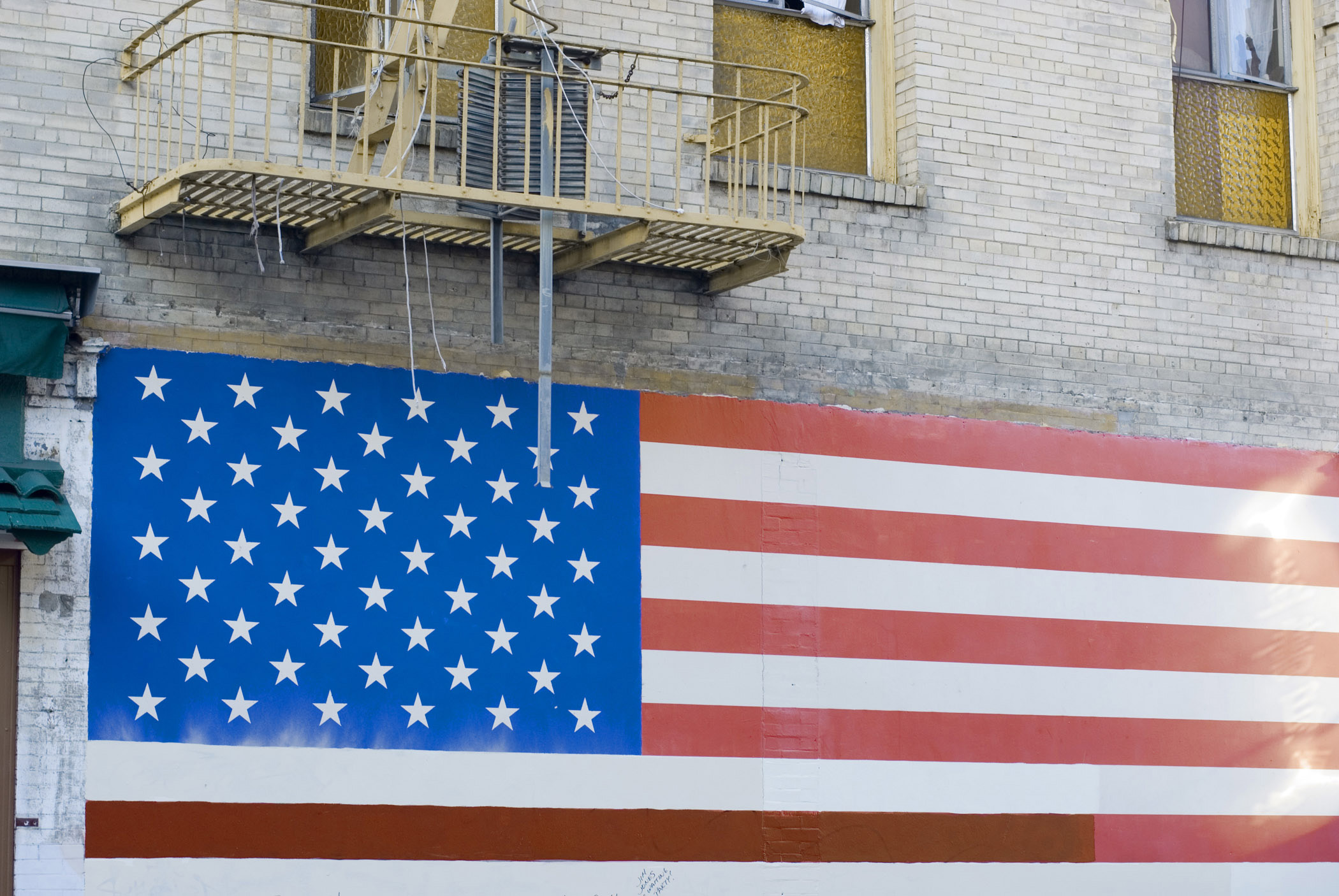 an image of Patriotic wall mural of the Stars and Stripes American national flag painted on the exterior wall of an old building