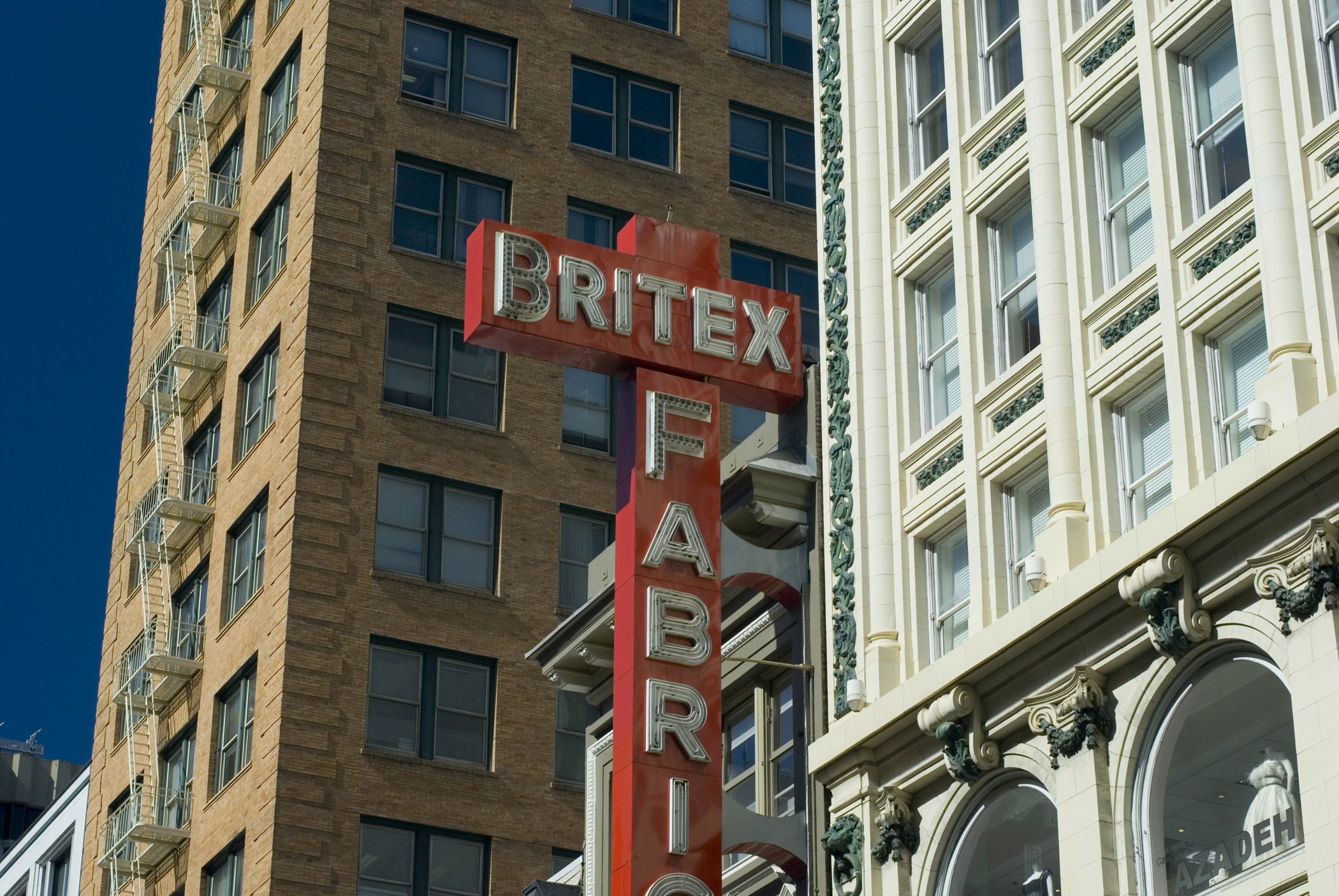 an image of San Francisco architecture with a view of the external facades of offices and apartments above commercial stores with signage for Britex