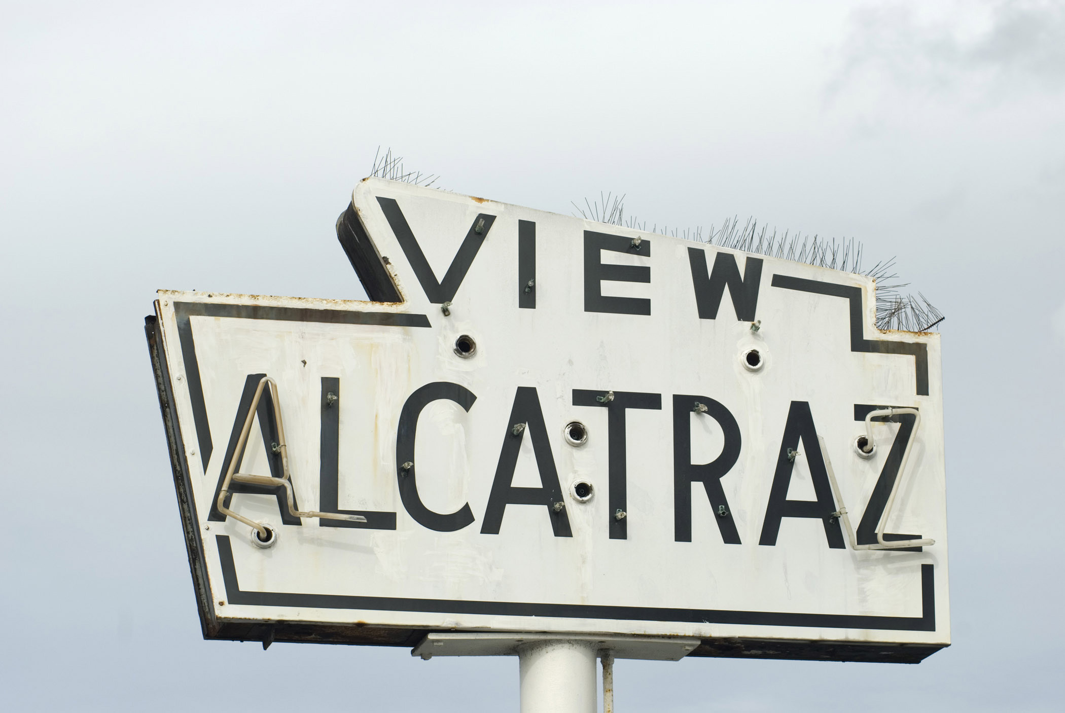 an image of Close up Vintage View Alcatraz Signage Found in San Francisco. Captured on Lighter Blue Gray Sky Background.