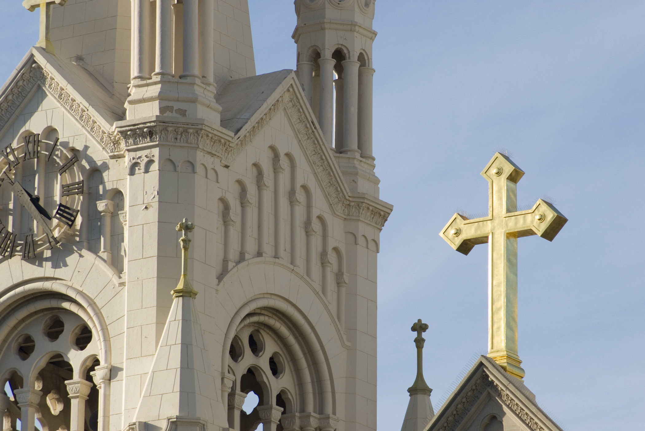 an image of Detail of the spire of the Church of Saints Peter and Paul with the clock and cross in Washington square, San Francisco, California