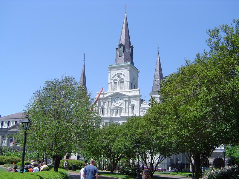 Old Vintage Architectural US Christian Church with Tall Trees on Front Landscape. Isolated on Light Blue Sky Background.