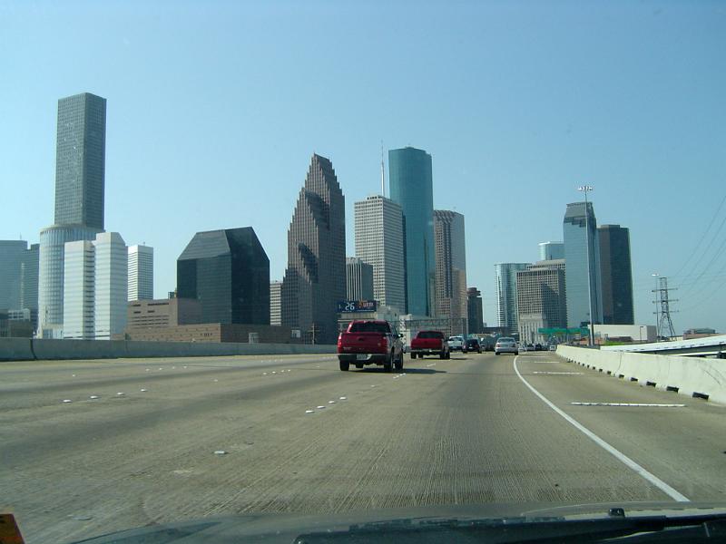 Cars driving on a freeway in America towards a city skyline with modern skyscrapers, drivers perspective